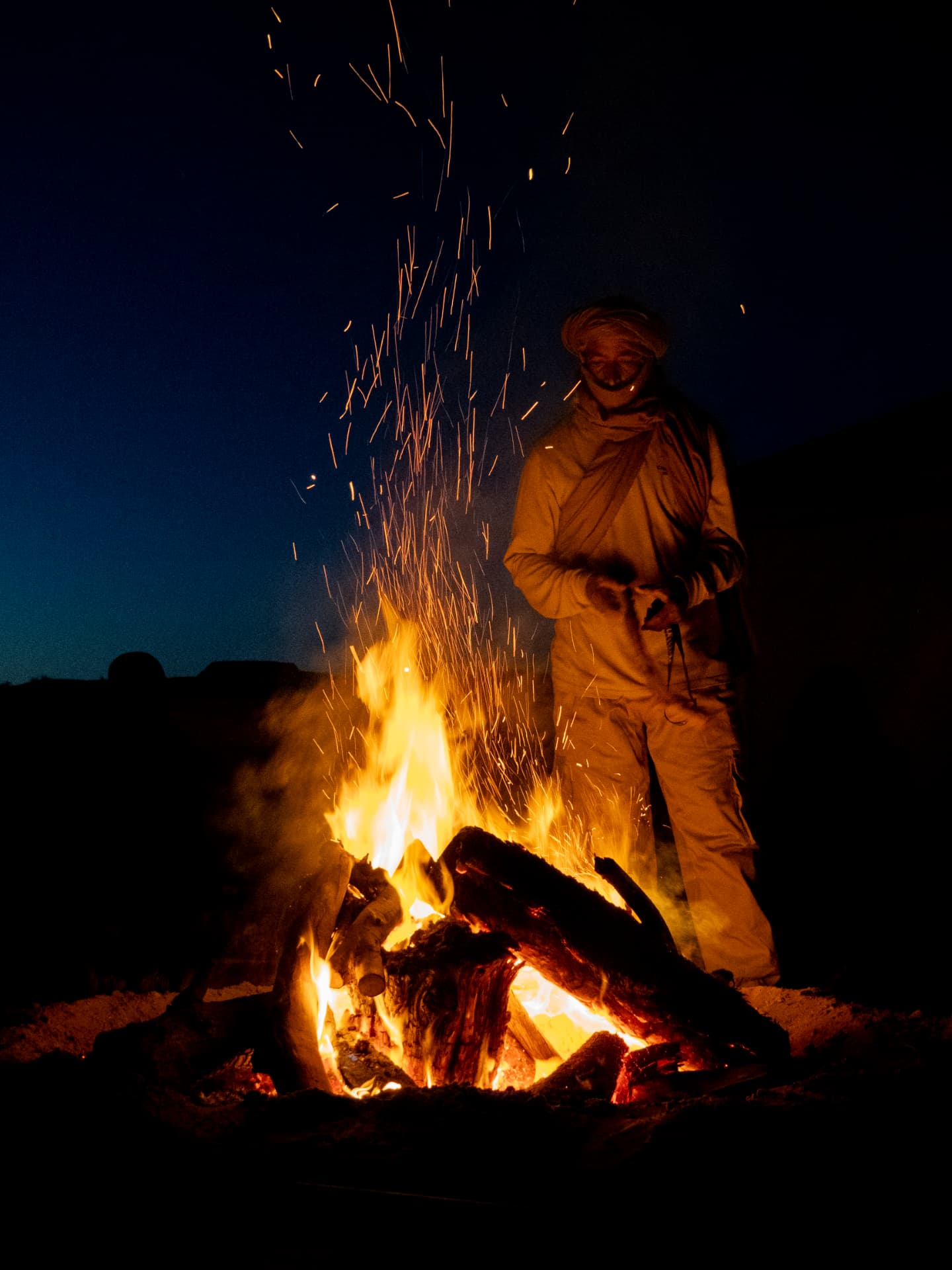 Feu de camp dans le désert avec un guide touareg